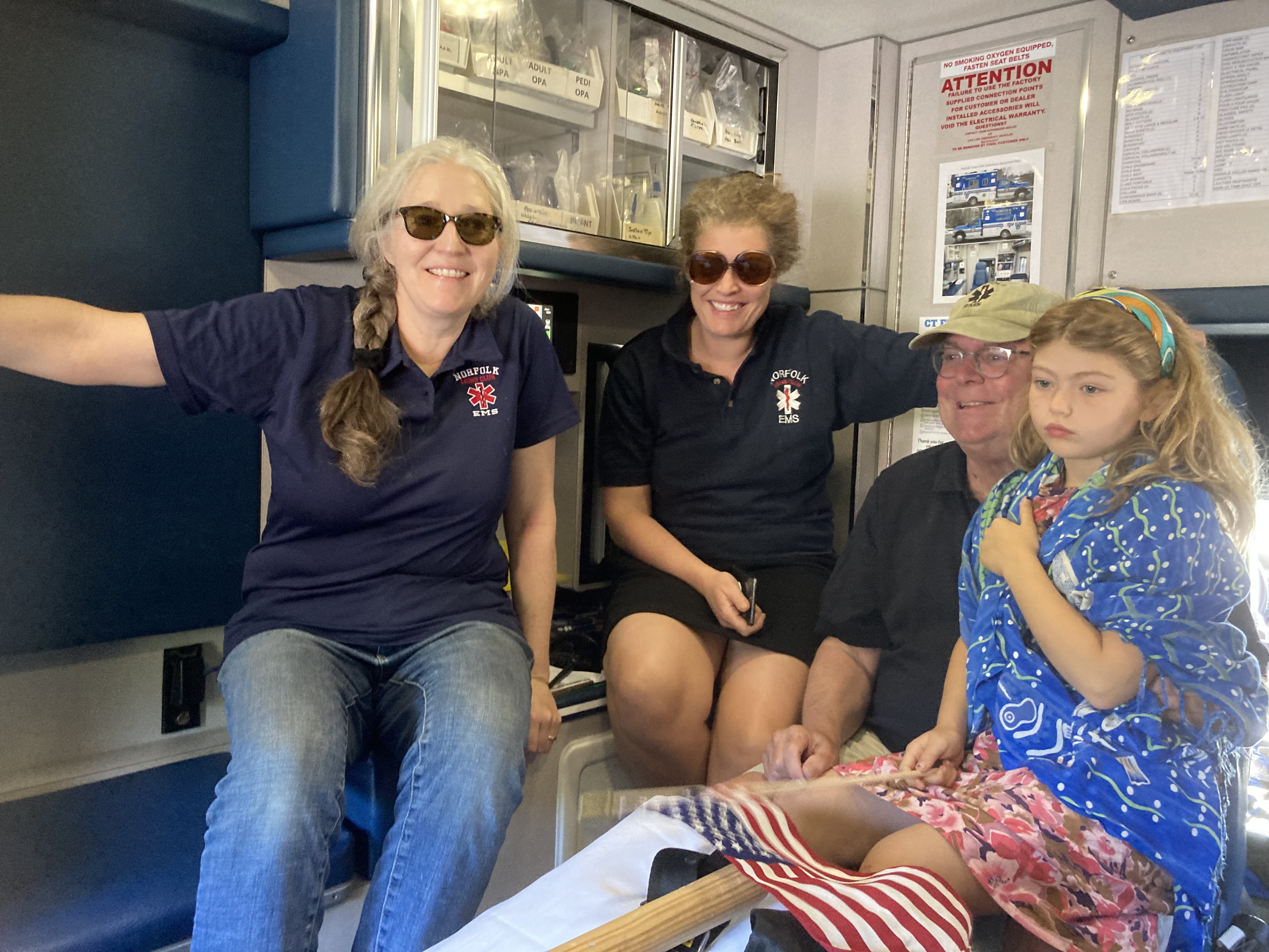 Volunteers with community members inside ambulance