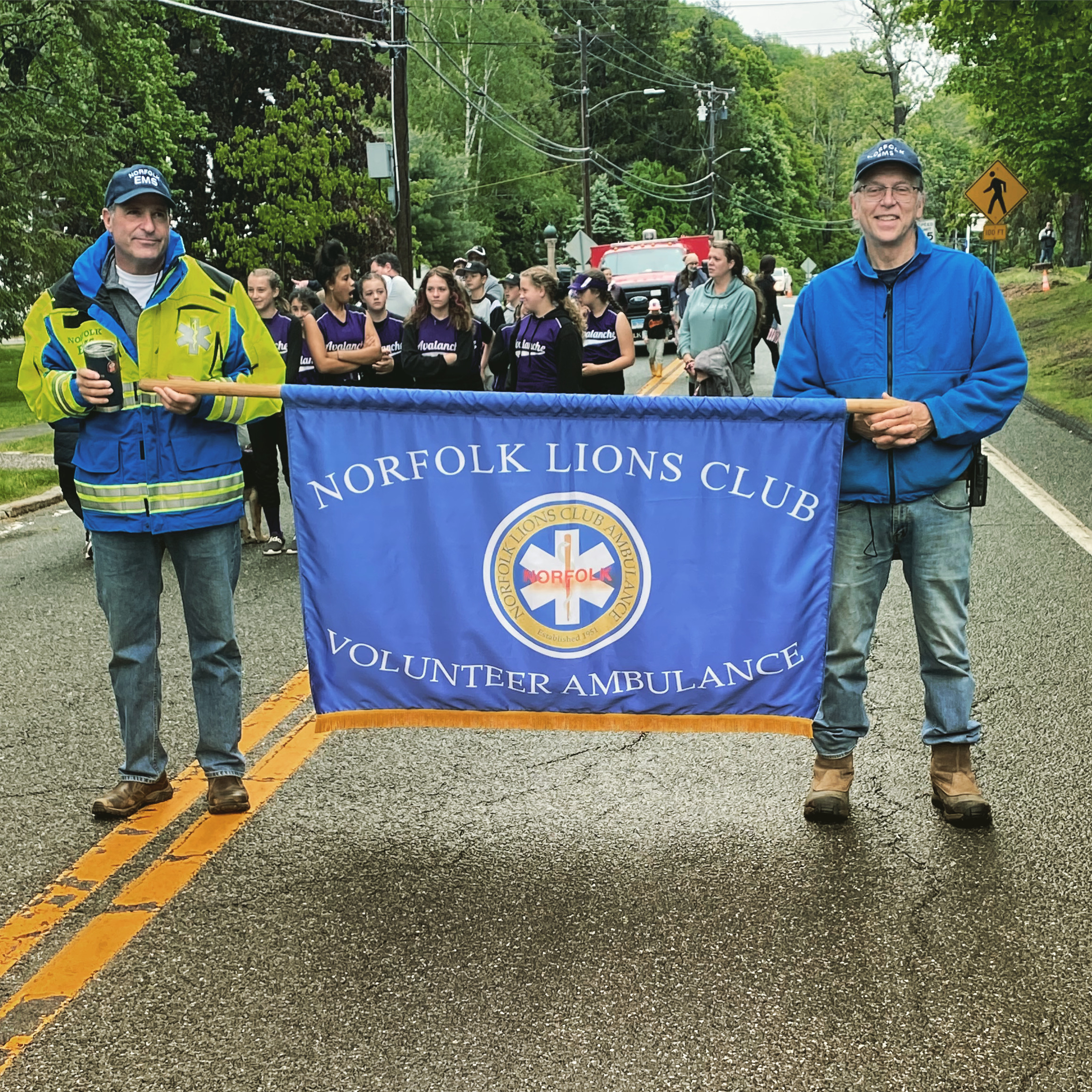 Volunteers with Norfolk Lions Club banner at parade
